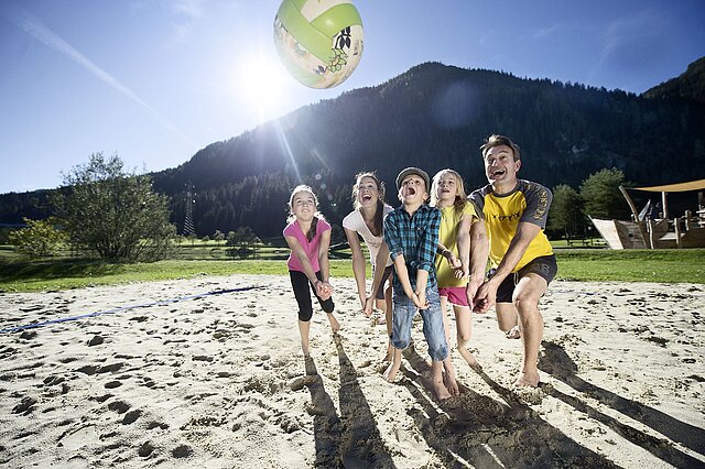 Familie beim Volleyballspielen am Badesee in Flachauwinkl.