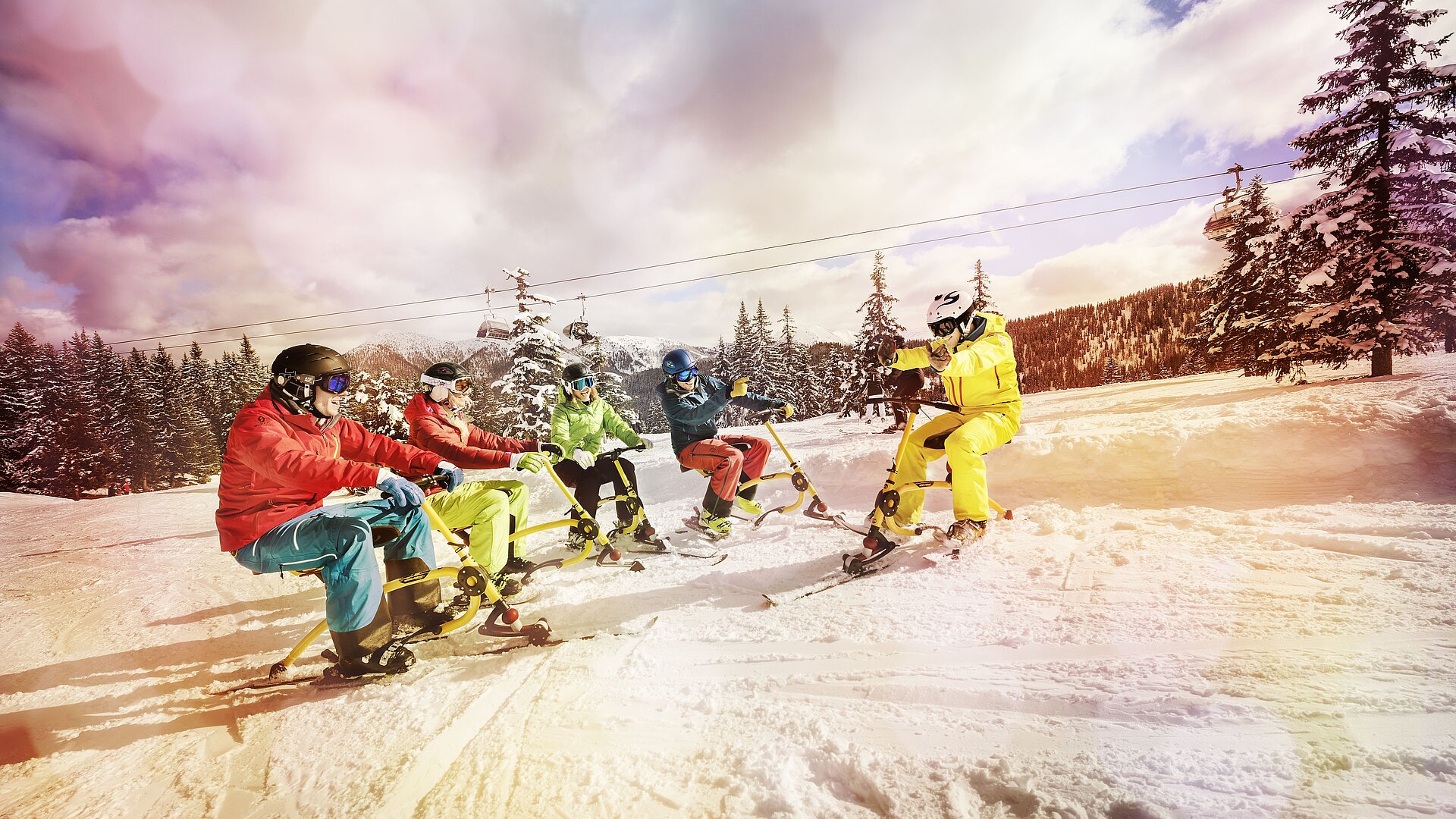 Eine Gruppe sitzt gemütlich auf ihren Snowbikes und freut sich schon auf spannende Abfahrten.